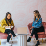 Two girls sitting and collaborating with a laptop