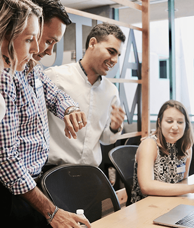 Four people in a conference room smiling