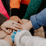 A group collectively putting their hands together