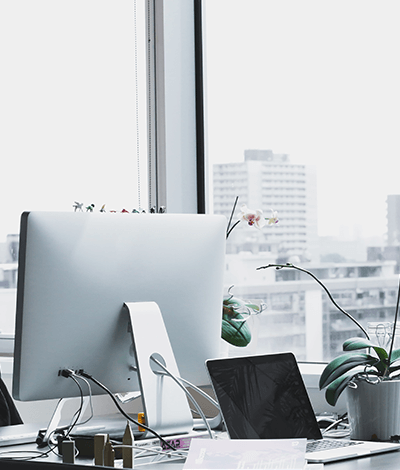 A computer in front of an airy window