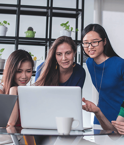 Three ladies looking at a laptop screen