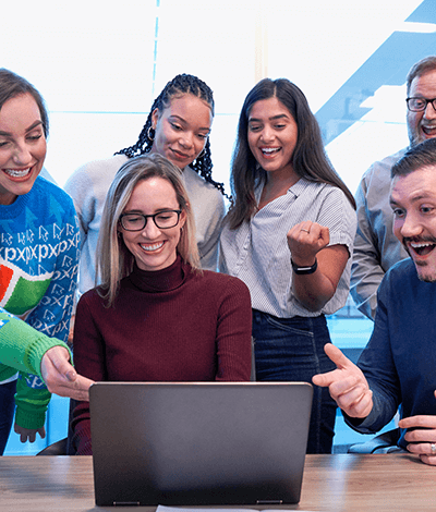 A group of people huddled around a laptop computer